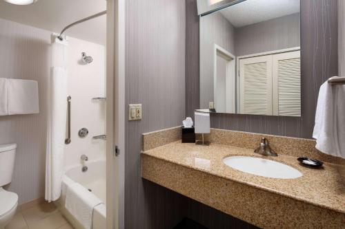 a bathroom with a sink and a toilet and a mirror at Sonesta Select Laguna Hills Irvine Spectrum in Laguna Hills
