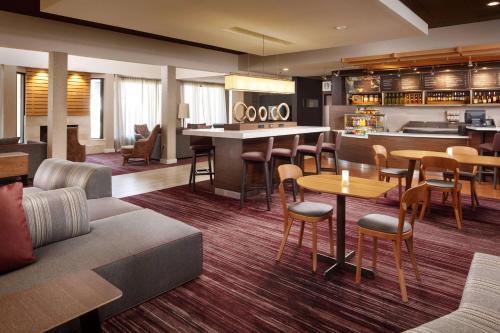 a hotel lobby with a bar and tables and chairs at Sonesta Select Laguna Hills Irvine Spectrum in Laguna Hills
