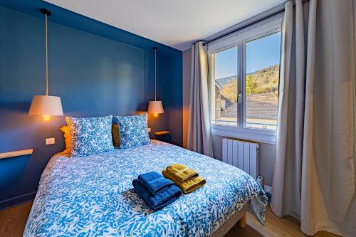 una camera blu con un letto e una grande finestra di Gîtes bo - Beaune - Saint Romain - classés 3 étoiles a Saint-Romain