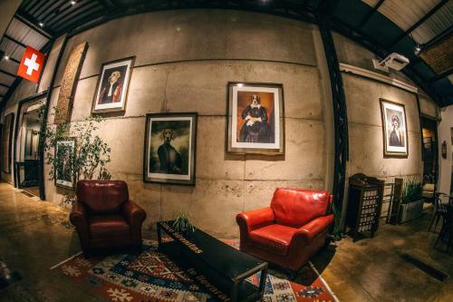 a room with two chairs and portraits on the wall at Alfonsina Hotel Boutique in Santa Cruz de la Sierra