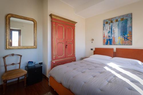 a bedroom with a bed with a red cabinet and a mirror at Residenza San Flaviano, Relais di Charme in LʼAquila