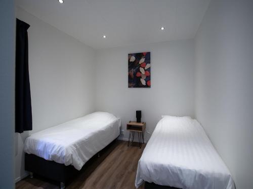 twee bedden in een kamer met witte muren bij Modern house with dishwasher, on a holiday park in a nature reserve in Rhenen