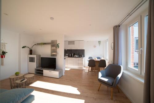 a living room with a couch and a chair and a kitchen at Schöne Ferienwohnung 54 m², Zentrumsnah, Kingbett in Erfurt