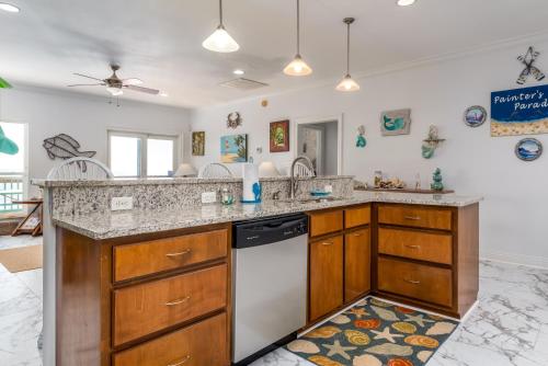 a kitchen with a sink and a dishwasher at West Beach - Stay ON the sand! Gulf views galore, only steps to the shore! home in Dauphin Island