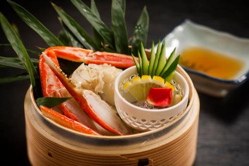 a bowl filled with different types of food on a table at Kawaguchiya Kinosaki Riverside Hotel in Toyooka