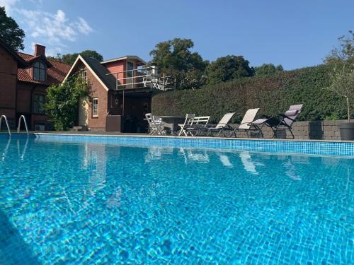 una gran piscina con sillas y una casa en Vingårdens Bed & Breakfast, en Helsingborg