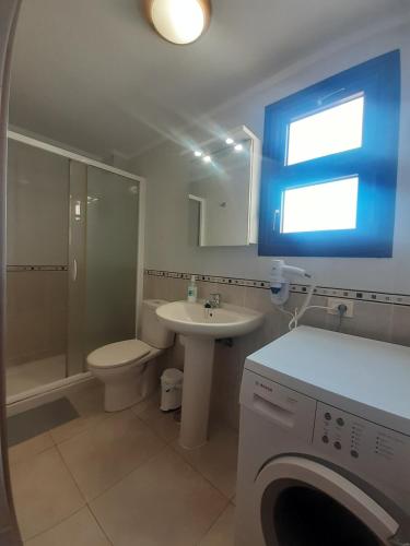 a bathroom with a toilet sink and a washing machine at Casa Yuni in Candelaria