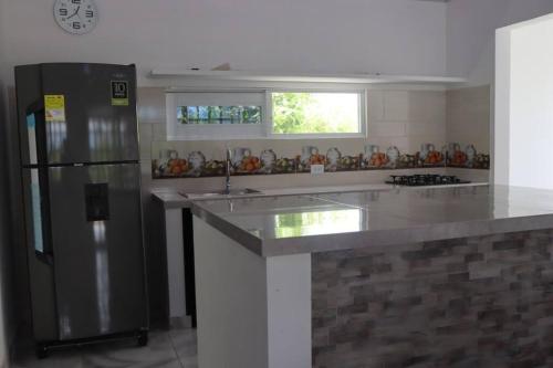 a kitchen with a stainless steel refrigerator and a counter at Finca Nuevo Sol (Hermosa casa de descanso) in Melgar