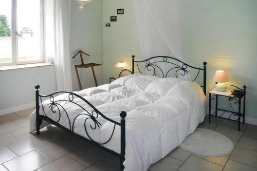 a bedroom with a large bed with white sheets at Lorraine country house near Lake Madine, Lahayville in Lahayville