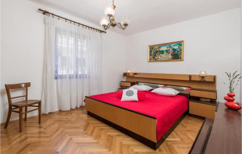 1 dormitorio con 1 cama roja y 1 silla en 2 Bedroom Awesome Apartment In Pag en Pag