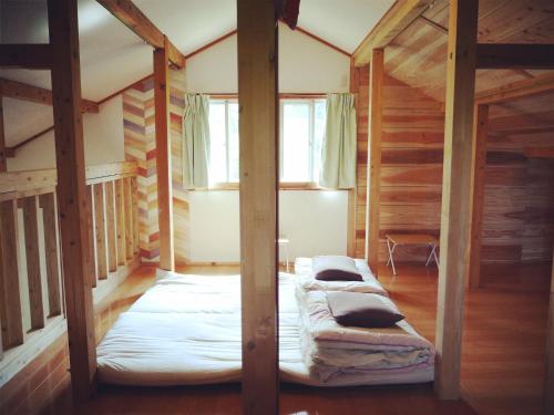 Dos camas en una habitación con paredes de madera. en Guest house iroha, en Nakijin