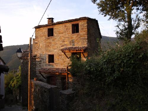 an old stone building on a hill with a tree at Casa Princesa Peralta in Lousã