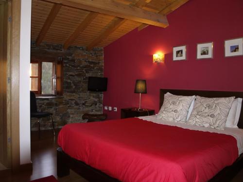 a red bedroom with a bed and a red wall at Casa Princesa Peralta in Lousã