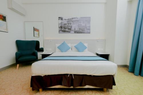 a bedroom with a large bed and a blue chair at Alamis City Kuala Lumpur - Formerly EDC Hotel Kuala Lumpur in Kuala Lumpur