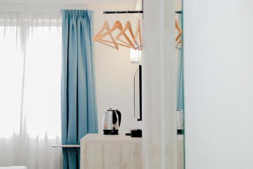 a room with blue and white curtains and a table at Alamis City Kuala Lumpur - Formerly EDC Hotel Kuala Lumpur in Kuala Lumpur