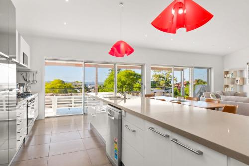a kitchen with red lights and a living room at Wahgunyah Road 52 in Nelson Bay