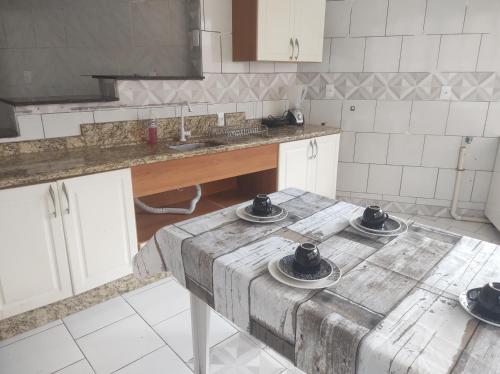 a kitchen with a table with three dishes on it at Apartamento amplo pé na areia - Itapema 180m da Praia in Itapema