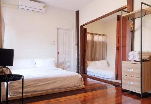 a bedroom with two beds and a mirror at ฮักเคียงโขง HUG Khieng Khong Nongkhai Hostel in Nong Khai