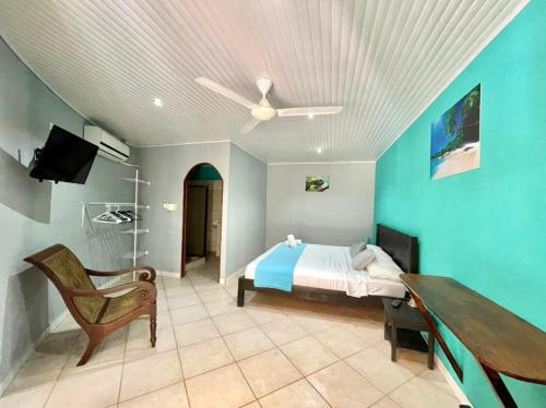 Schlafzimmer mit einem Bett und einem Deckenventilator in der Unterkunft Hospedaje Colibri in Manuel Antonio