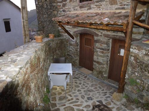 a table and a chair in a stone building at Casa Princesa Peralta in Lousã