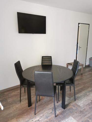 - une table avec des chaises et une télévision dans la chambre dans l'établissement Joli Appartement 2 pièces 4 voyageurs tout équipé 13 avenue de la Divette 14390 CABOURG, à Cabourg