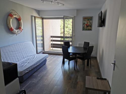 een woonkamer met een bed en een tafel en stoelen bij Joli Appartement 2 pièces 4 voyageurs tout équipé 13 avenue de la Divette 14390 CABOURG in Cabourg