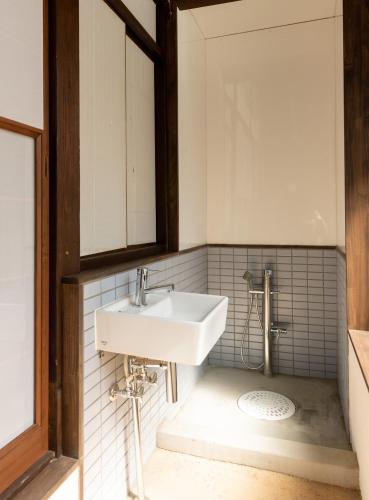 a bathroom with a sink and a mirror at Kohaku AMBER Kamakura Zaimokuza in Kamakura
