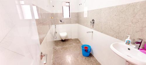 a white bathroom with a sink and a toilet at Entire Apartment -Pradhan Nagar Middle of the city in Siliguri