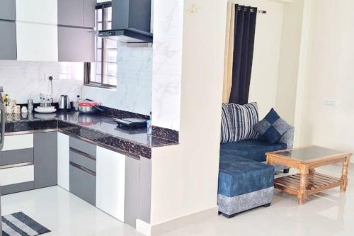 a kitchen with a table and a couch in a room at Entire Apartment -Pradhan Nagar Middle of the city in Siliguri