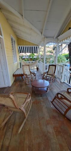 a porch with chairs and a table and a coffee table at Looking Good Surf House San Juan del Sur in San Juan del Sur