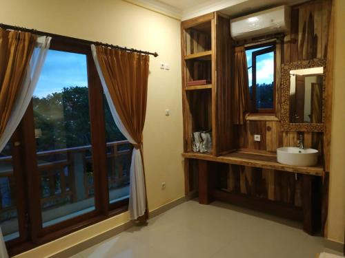 a bathroom with a window with a sink and a mirror at Bali Soul Guest House & Apartments in Ubud
