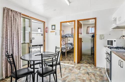 uma cozinha e sala de jantar com mesa e cadeiras em Rock’s Retreat - cabin 1 (seal) em Carpenter Rocks