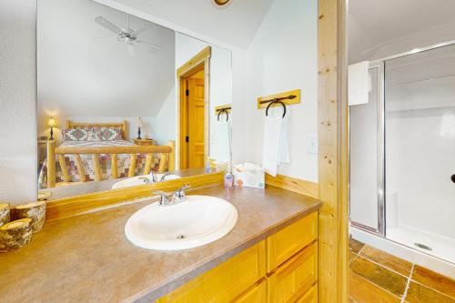 a bathroom with a sink and a shower and a mirror at Cinnamon Teal Chalet in Redmond