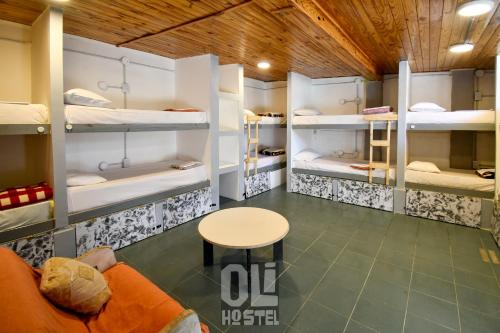 a room with three bunk beds and a table at Oli Hostel in San Rafael