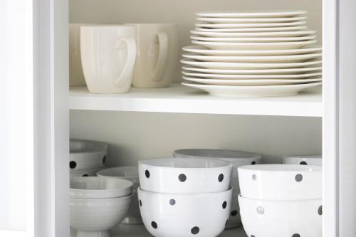 a shelf filled with white bowls and plates at Monochrome in Yomitan