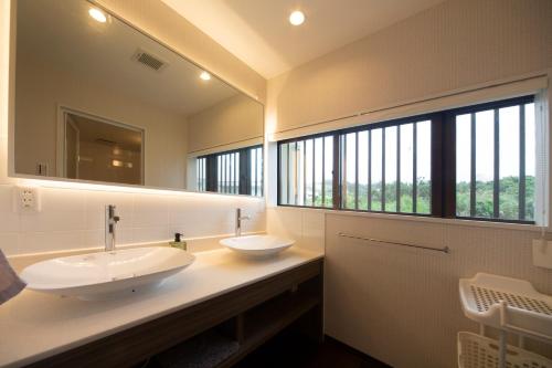 a bathroom with two sinks and a large mirror at 恩納村カーチーベー in Meta