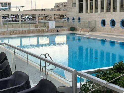 a large swimming pool with blue water in a building at RAG Marine Winner - Lovely Sea Front luxury in Herzliya B