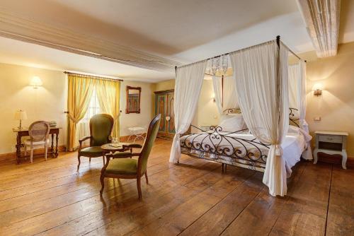 a bedroom with a canopy bed and a table and chairs at Au Fil du Temps in Imbsheim