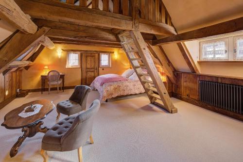 een slaapkamer op zolder met een bed en een trap bij Au Fil du Temps in Imbsheim