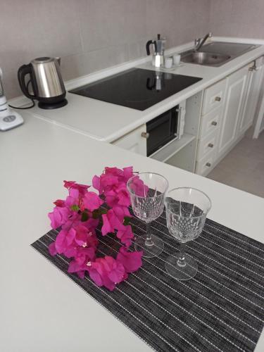 una cucina con due bicchieri e fiori rosa su un bancone di Bruna's house ad Adeje