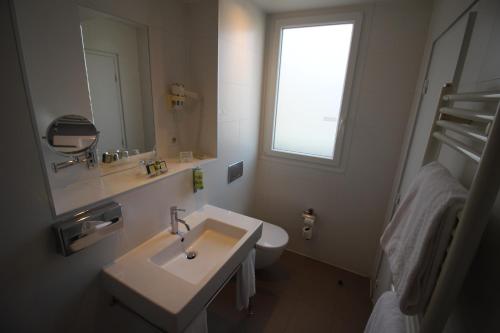 a bathroom with a sink and a toilet and a window at Holiday Inn Paris-Auteuil by IHG in Paris