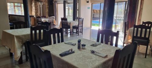 a dining room with two tables and chairs and a table and chairs at Heimat Guesthouse in Welkom