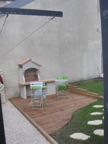 a patio with two chairs and a table and a grill at Villa Étienne in Le Mont-Dore