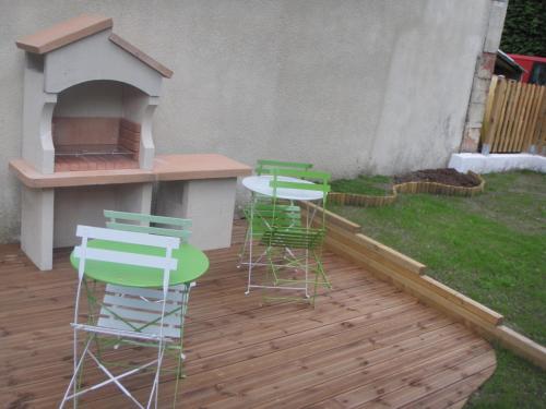 a patio with four chairs and a table and a grill at Villa Étienne in Le Mont-Dore