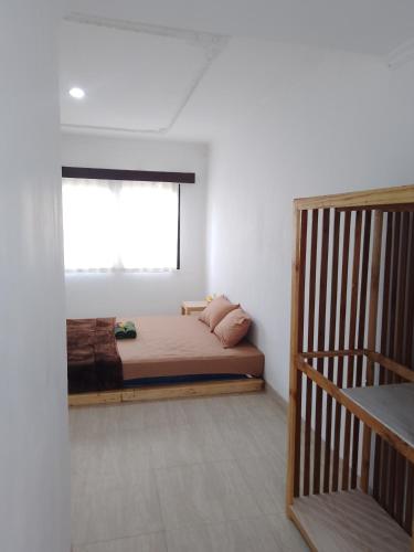 a bedroom with a bed with a window and a staircase at A&B Homestay and Kitchen in Nusa Dua