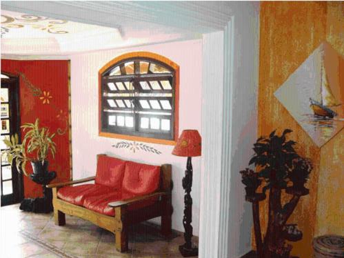a living room with a red couch and a window at Peruíbe Suíte Flat Hotel in Peruíbe