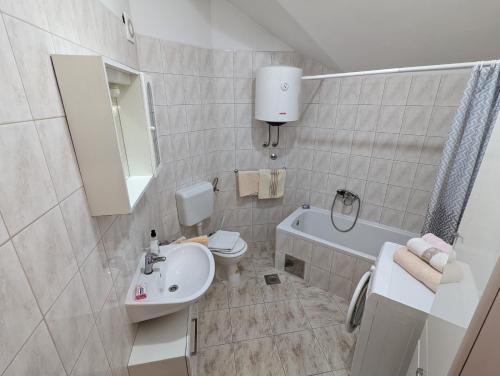 ein Badezimmer mit einem Waschbecken, einem WC und einer Badewanne in der Unterkunft Bellino penthouse in Korčula