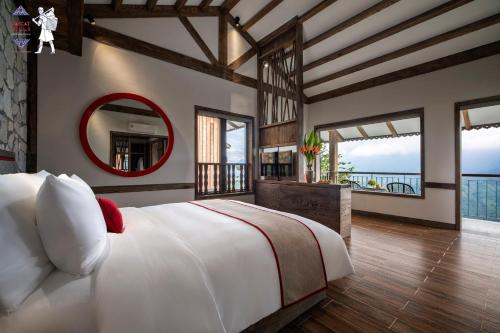 um quarto com uma cama grande e um espelho em Sapa Catcat Hills Resort & Spa em Sa Pa