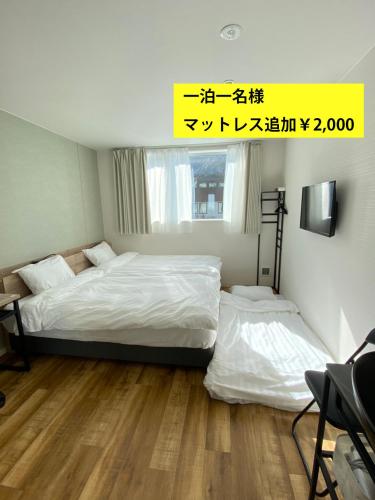 two beds in a small room with at Megu Fuji 2021 in Fujiyoshida