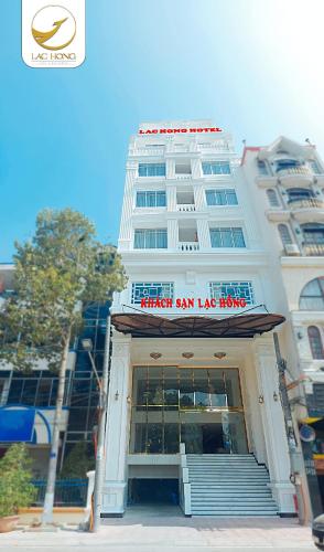 a white building with a sign on the front of it at Khách Sạn Lạc Hồng Mỹ Tho - Lac Hong My Tho Hotel in My Tho